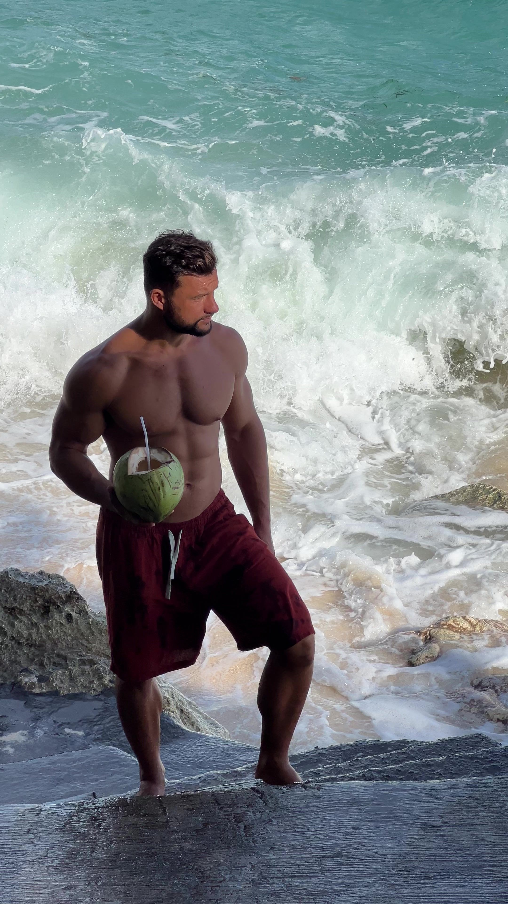 Remus Boroiu cu o nucă de cocos lângă ocean în Bali